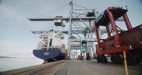 Breathtaking View of Harbour Cranes Moving Container Cargo Against Clear Sky