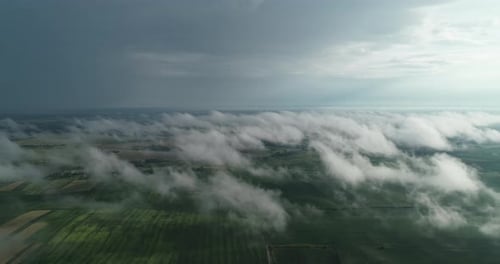 Durch die Wolken öffnet sich eine wunderschöne Landschaft aus Feldern und Straßen mit Transportmitteln