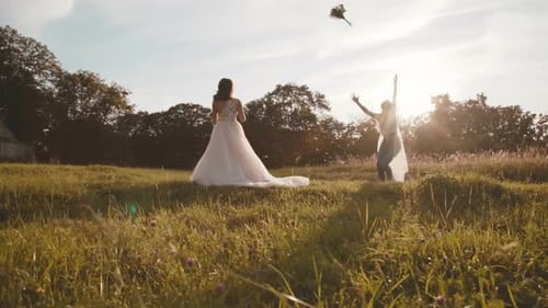 Bride Tosses Bouquet in Grassy Field