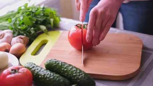 Cutting a Red Tomato on a Wooden Cutting Board