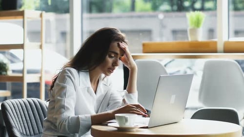 Upset Freelance Woman Can't Deal with Work While Sitting in Modern Cafe