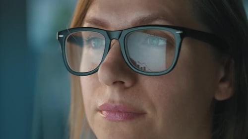 Woman in Glasses Looking on the Monitor and Working with Charts and Analytics