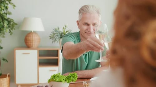 Les aînés tintent des verres à vin pendant le dîner
