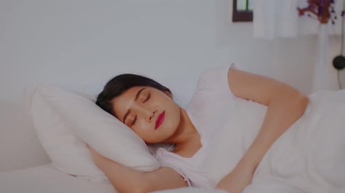Young Woman Sleeping Peacefully in Bed at Home