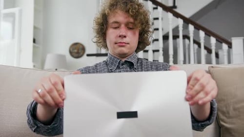 Young Male Office Worker with Curly Hair which Starting to Work on Laptop from Home