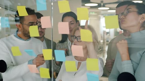 Team Analyzing Sticky Notes in an Office