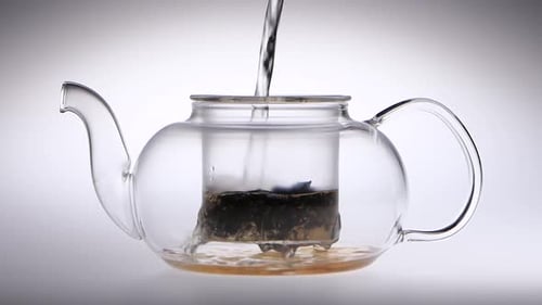 Pouring Water into a Glass Teapot