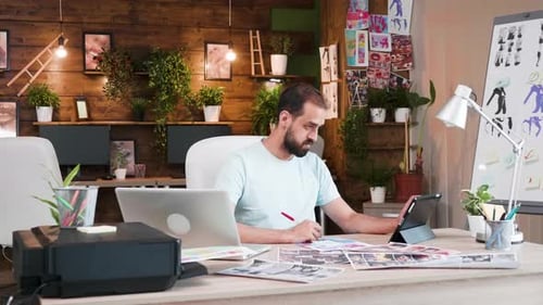 Man Working on Tablet then Laptop at Desk