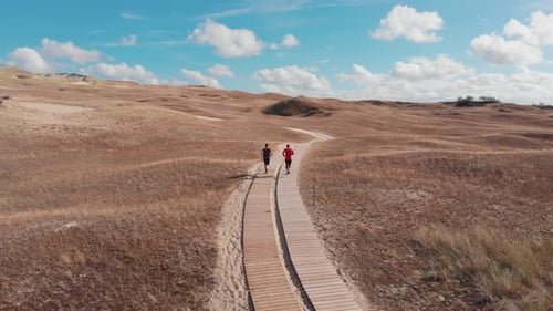 Gente corriendo en camino a través de las dunas