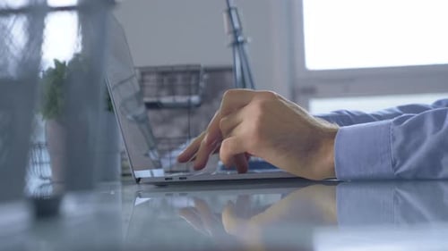 Close Up Male Fingers Typing on A Laptop Keyboard Using A Computer In A Bright Room At Home