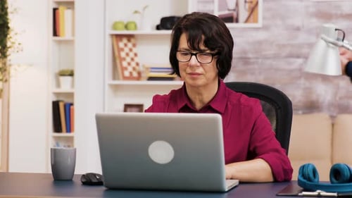 Woman Works on Laptop in Her Home Office