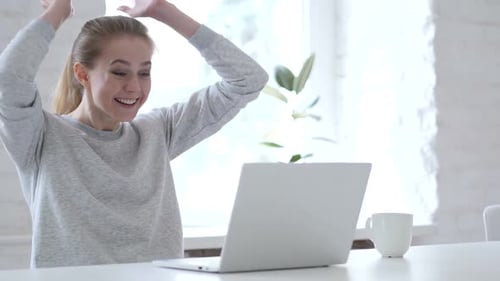 Woman Typing on Laptop Celebrates Success