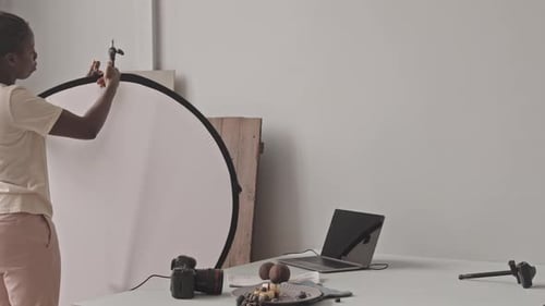 Woman Setting Up Photography Equipment to Photograph Food