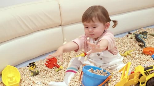 Portrait d'un enfant en bas âge de deux ans jouant au seau de jouets dans un café. Gros plan