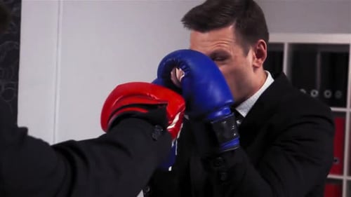 Two Businessmen Boxing in Office Room