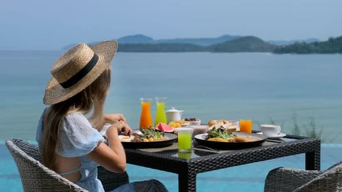 Young Woman Relax in Tropical Resort Having Breakfast in Restaurant with Sea