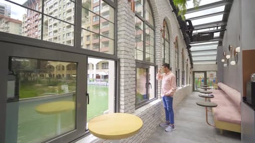 Young Adult Drinking Coffee by a Window
