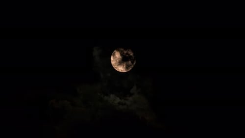 Full Moon Emerges from Dark Clouds at Night