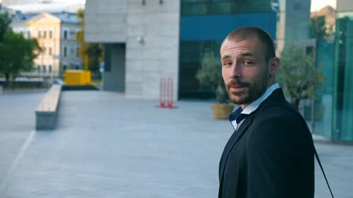 Handsome Businessman Talking on Phone Near Office and Looking at Camera. Young Business Man Speaking