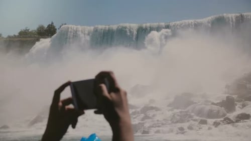 Slow Motion Close-up Human Hands Taking Smartphone Photos of Epic Niagara Falls Waterfall Panorama