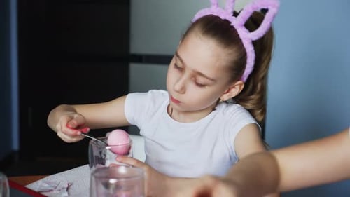 Girl Decorating Easter Eggs at Home