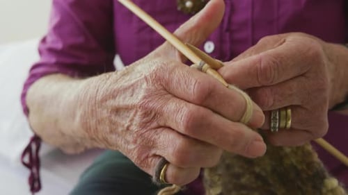 Close-Up of Elderly Hands Knitting Yarn with Needles