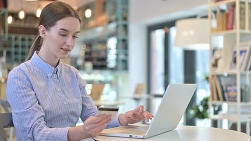 Online Payment on Laptop By Young Businesswoman in Cafe