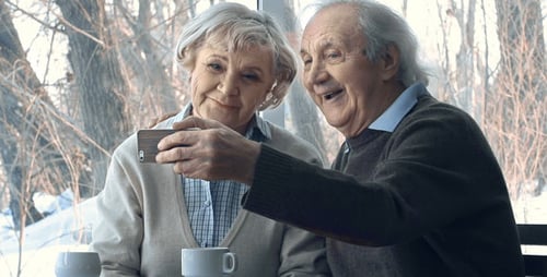 Senior Couple Watching Phone Together on Winter Day