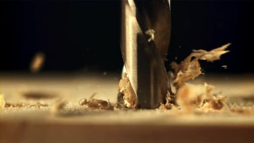 Drill Bit Drilling into Wood with Wood Shavings