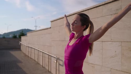 Woman Stretching Arms Outdoors in Urban Setting