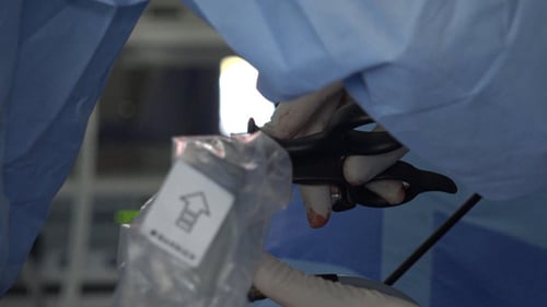 Surgeon Opens Medical Equipment with Scissors in Hospital