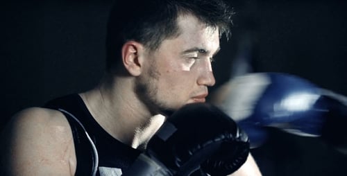 Focused Young Adult Boxer Punching in Close Up
