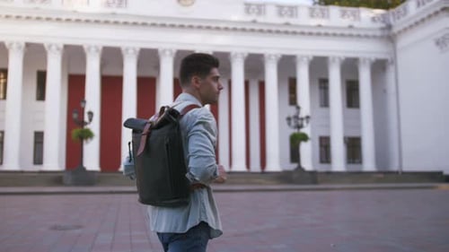 Attractive Young Handsome Man Tourist with Backpack Walking in City Center
