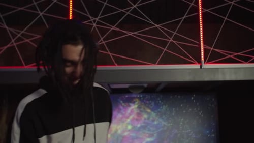 DJ Dancing to Music Under Red Lights