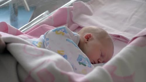 Madre que cubre al bebé dormido con una manta