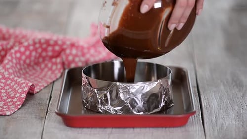 Woman's Hands Pouring Cake Batter Into Cake Mold, Ready To Bake.