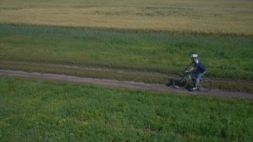 Man Cycling On a Rural Road Aerial View