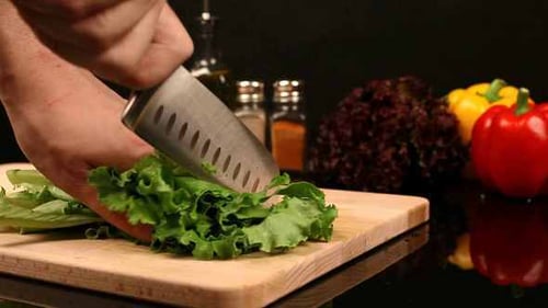 Green Lettuce Being Cut on Cutting Board