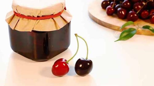 Pot de confiture de cerises et récolte de cerises fraîches