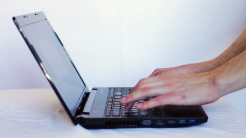 Hands Typing on Laptop Computer Keyboard Close Up