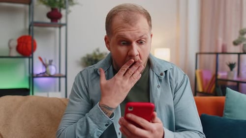 Man Reacts with Surprise to Something on Phone