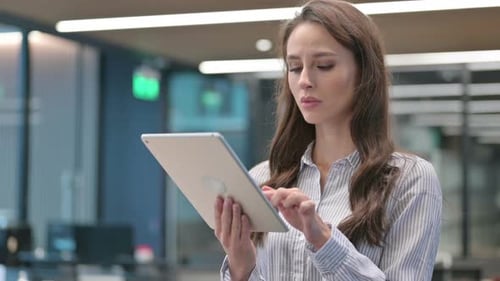 Woman Using Tablet in Modern Office Environment