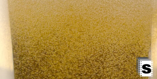 Bubbles Rising in Light Brown Drink