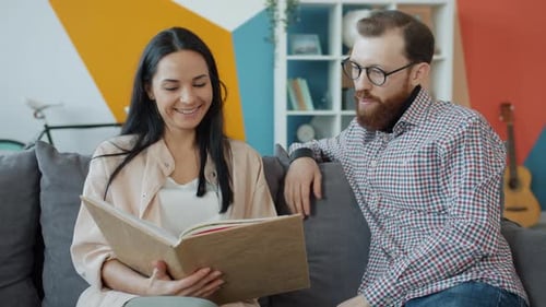 Couple Looking Through Photo Album at Home