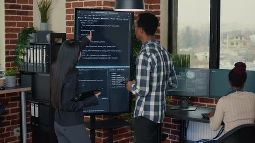 Software Engineers Analyzing Code on Wall Screen Tv Comparing Errors Using Digital Tablet