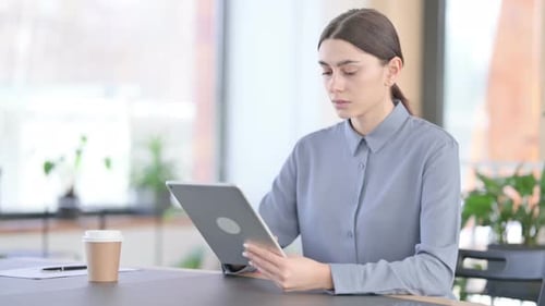 Woman Works on Tablet at Office Desk