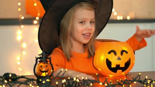 Fröhliches Mädchen im Hexenkostüm Fun Casts verzaubern Shining Pumpkin