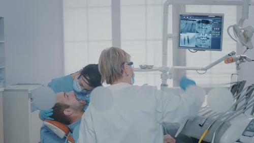 Dentist and Assistant Treating Patient in Clinic