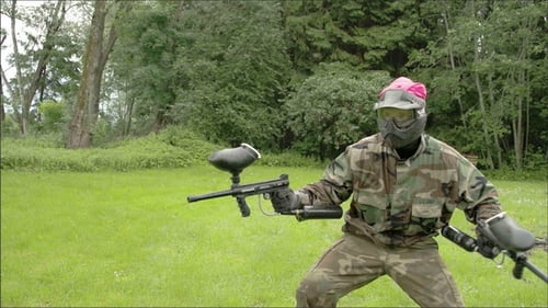 Ein Mann im rosa Team hält zwei Paintball-Waffen
