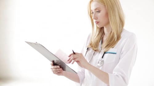 Female Doctor Reading Documents At Hospital